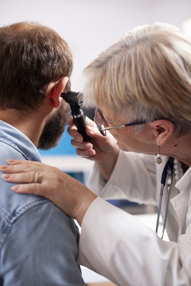 expert from earwax removal clinic examining ear